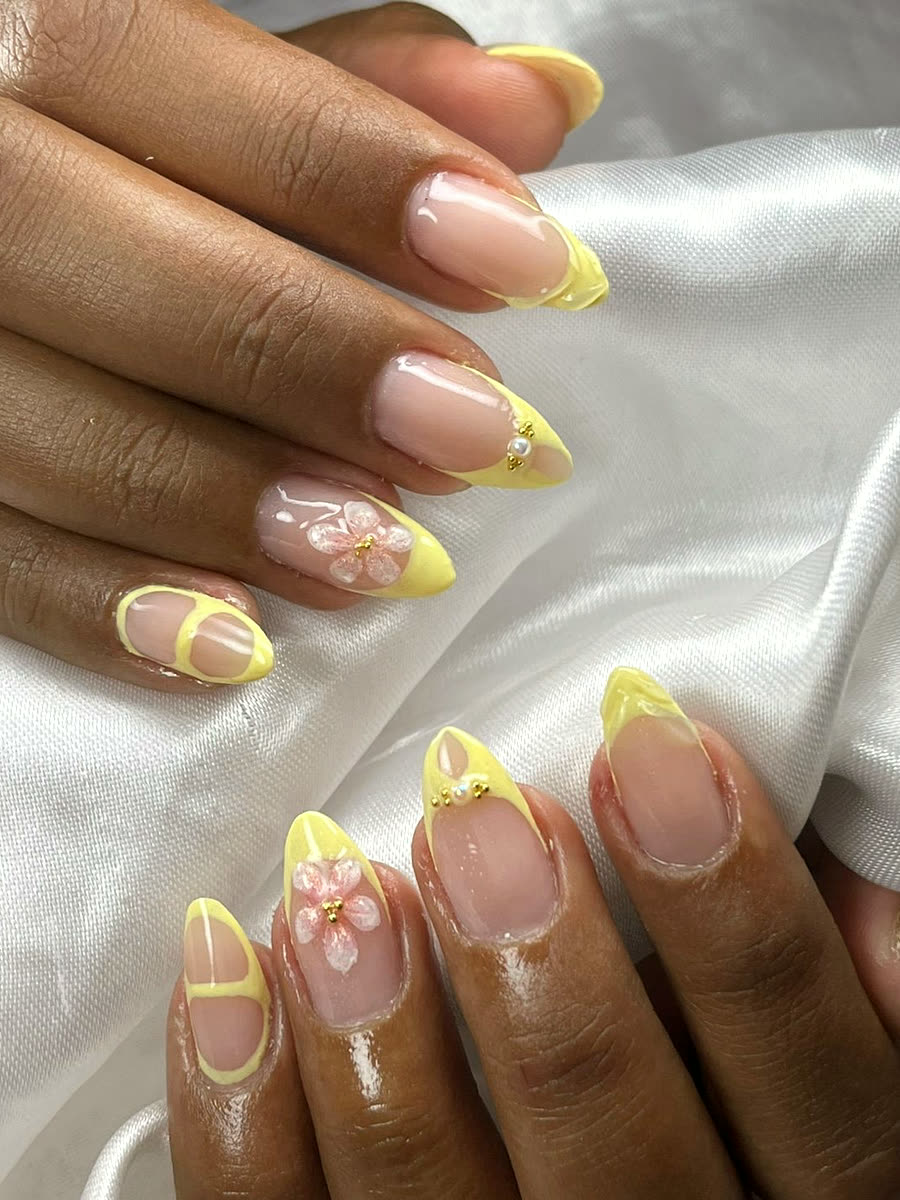 Francesinha amarela em unhas amendoadas, com flor rosa desenhada