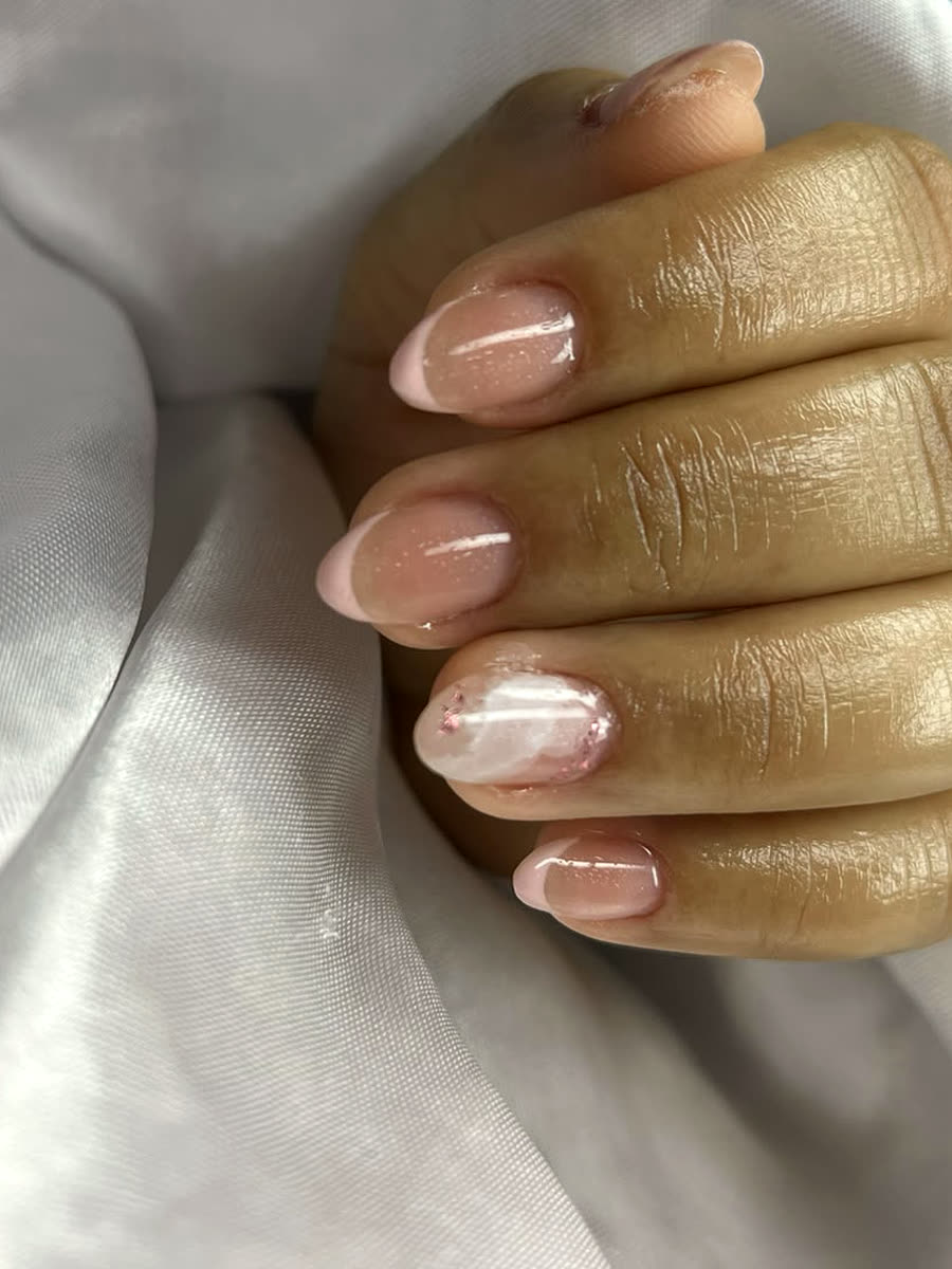 Unhas amendoadas com blindagem decorada, francesinha rosa e uma unha com arte