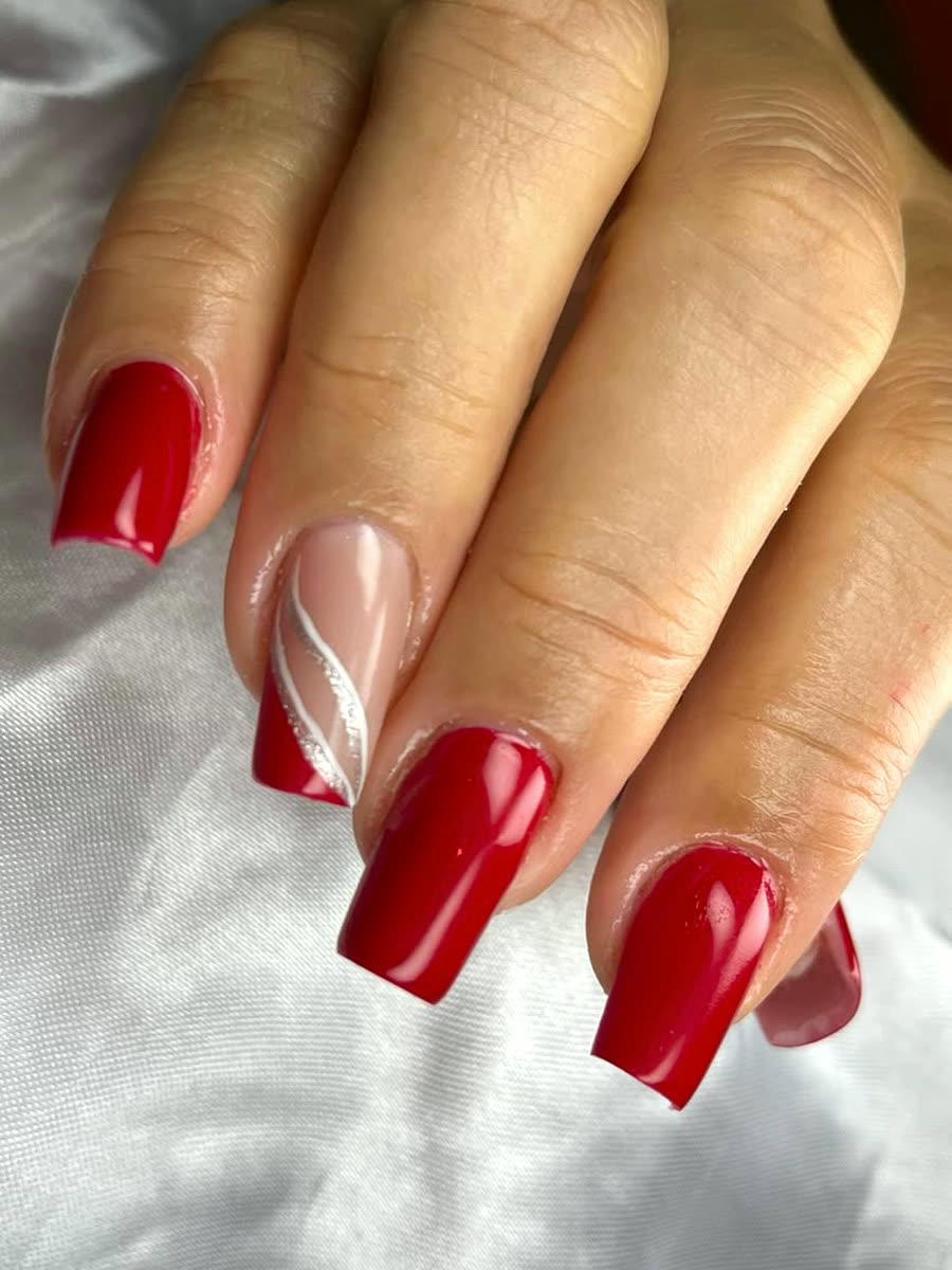 Unhas quadradas vermelhas com uma unha nude e traço vermelho